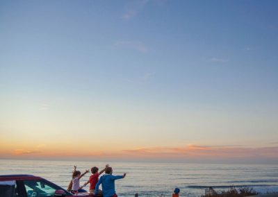 Rodzina podziwiająca zachód słońca nad morzem