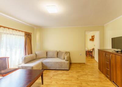 Pokój dzienny w domku murowanym z narożnikiem i TV